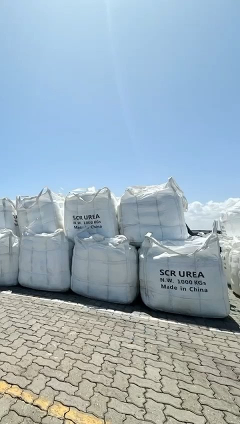 Cargas ensacadas no cais, com identificação de ureia visível em algumas embalagens.